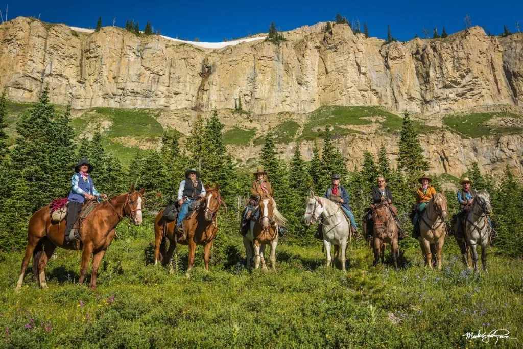 Guided horseback pack trip approaching the Chinese Wall in the Bob Marshall Wilderness